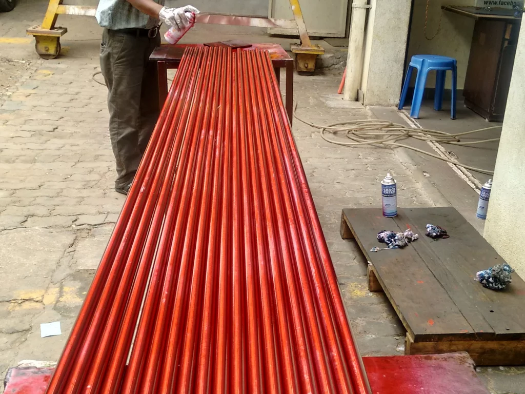 DPT testing of forged bars using red colour dye penetrant solvent removable process