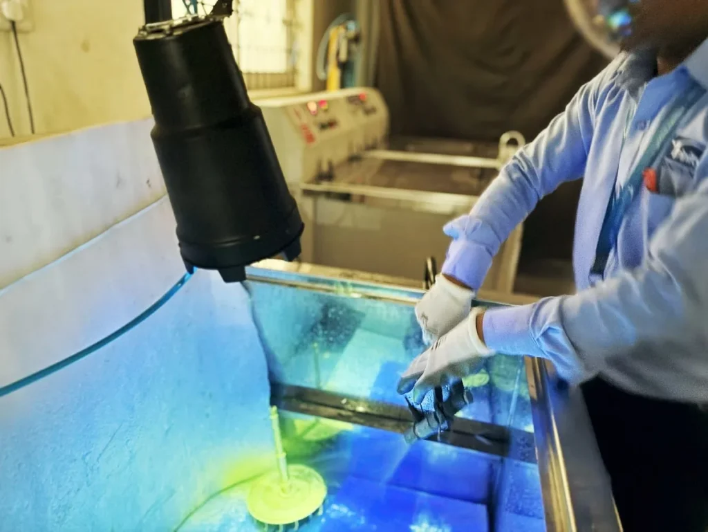 Fluorescent penetrant inspection of a component under UV-A light at Trinity NDT laboratory, Bangalore